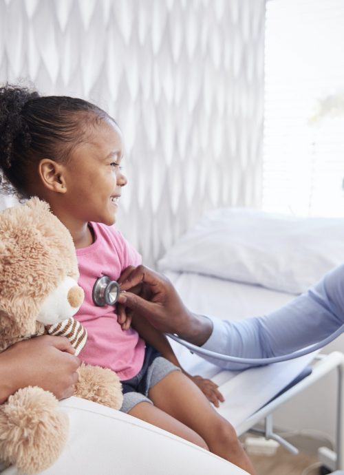 Mother Taking Daughter For Medical Exam In Doctors Office